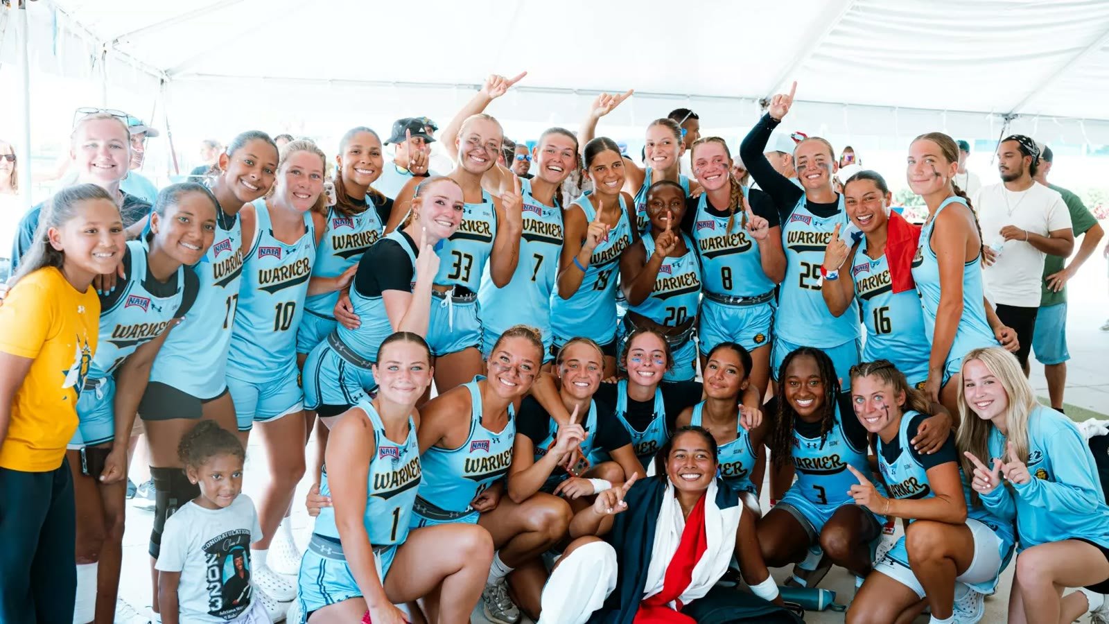 Warner University flag football team celebrating together